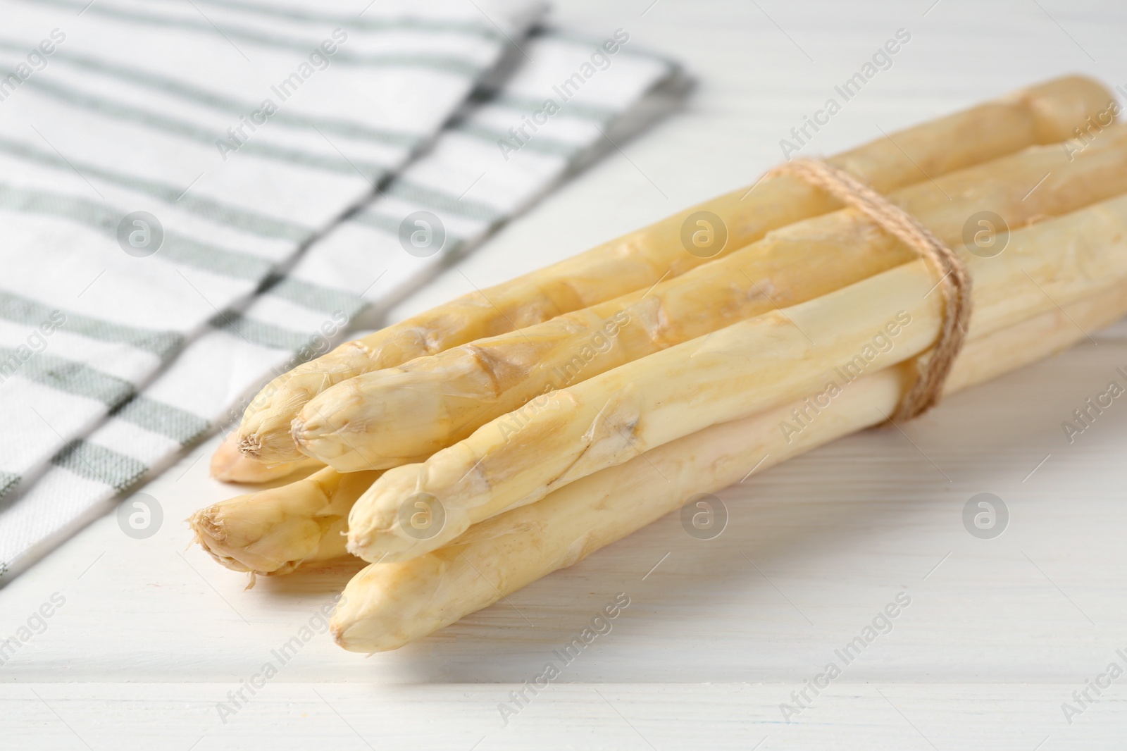 Bunch of raw asparagus spears on white wooden table, closeup Photo of Bunch of raw asparagus spears on white wooden table, closeup