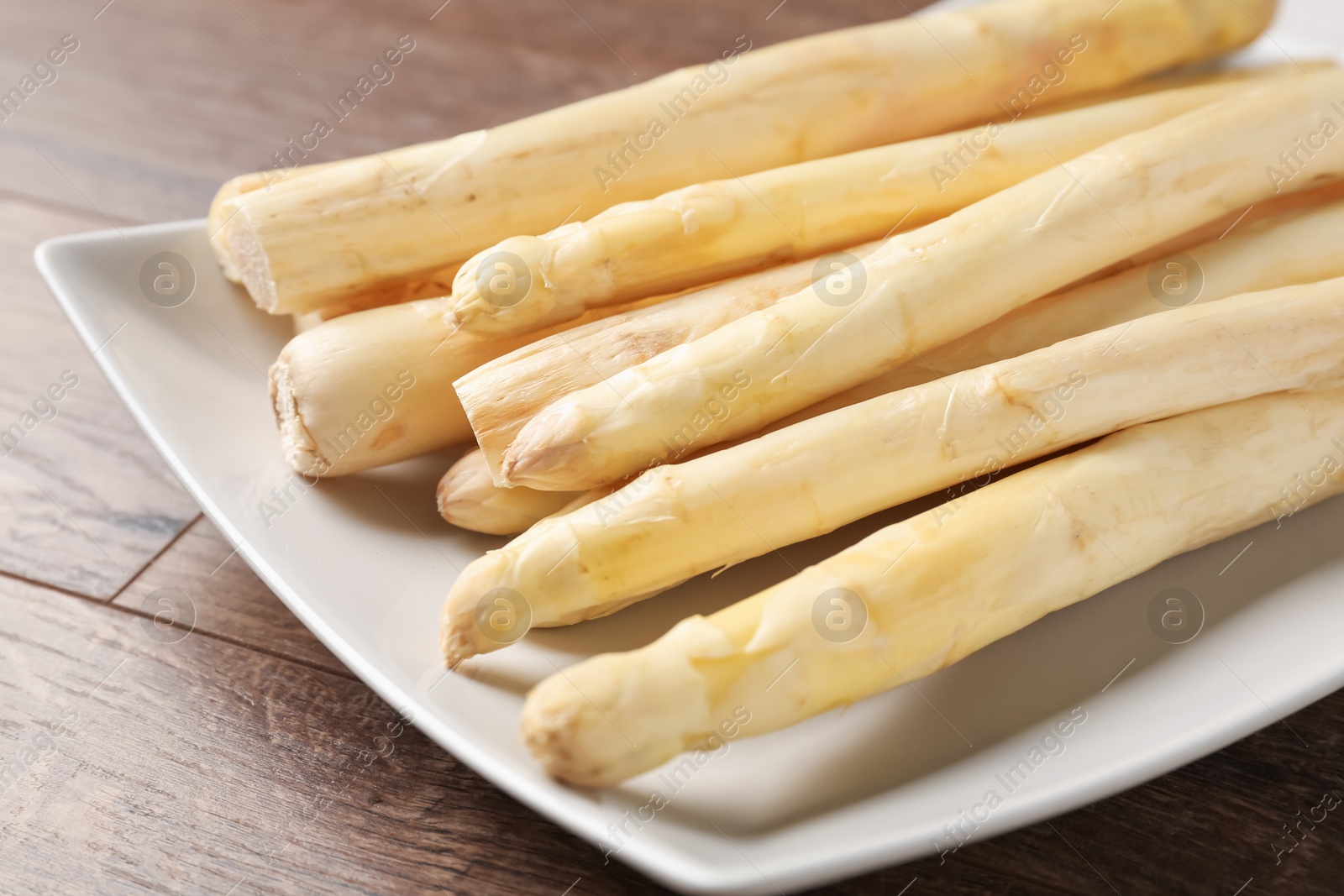 Raw white asparagus spears on wooden table, closeup Photo of Raw white asparagus spears on wooden table, closeup