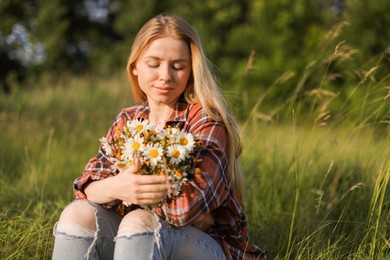 Photo of Beautiful woman with wildflowers enjoying summer day in meadow. Space for text