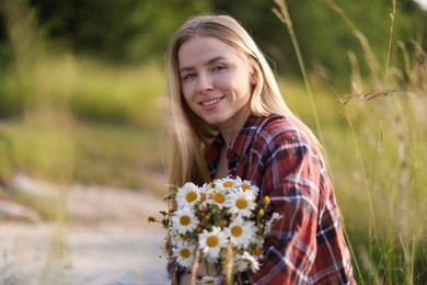 Photo of Beautiful woman with bouquet of wildflowers in meadow. Space for text