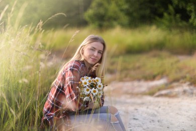 Photo of Beautiful woman with bouquet of wildflowers in meadow. Space for text