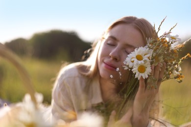 Photo of Beautiful woman with wildflowers in meadow on sunny day