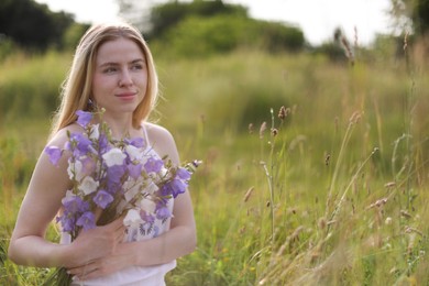 Photo of Beautiful woman with bouquet of wildflowers enjoying sunny day in meadow. Space for text