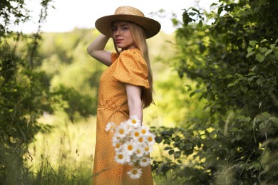 Photo of Beautiful woman with bouquet of wildflowers in forest