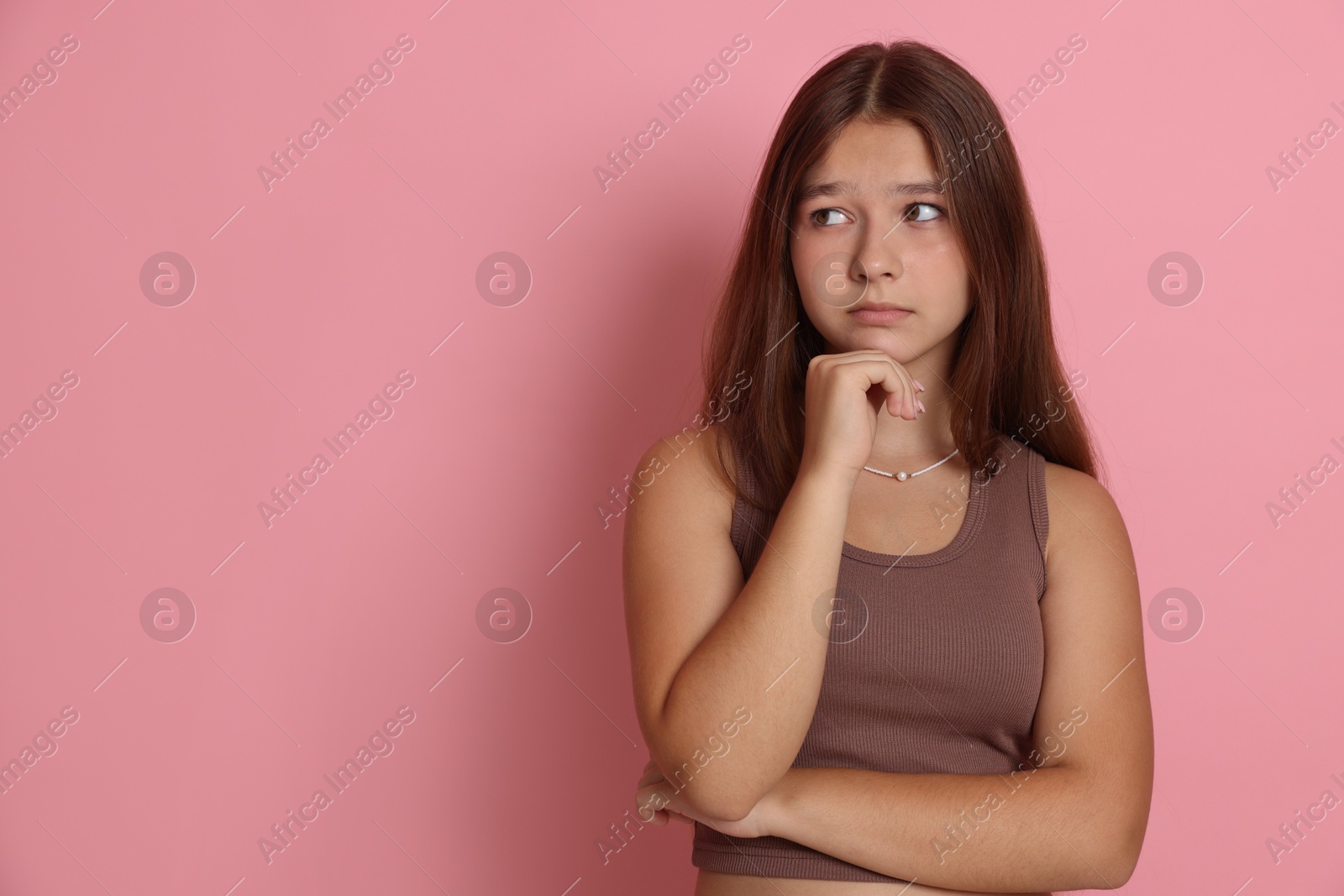 Portrait of teenage girl on pink background, space for text Photo of Portrait of teenage girl on pink background, space for text