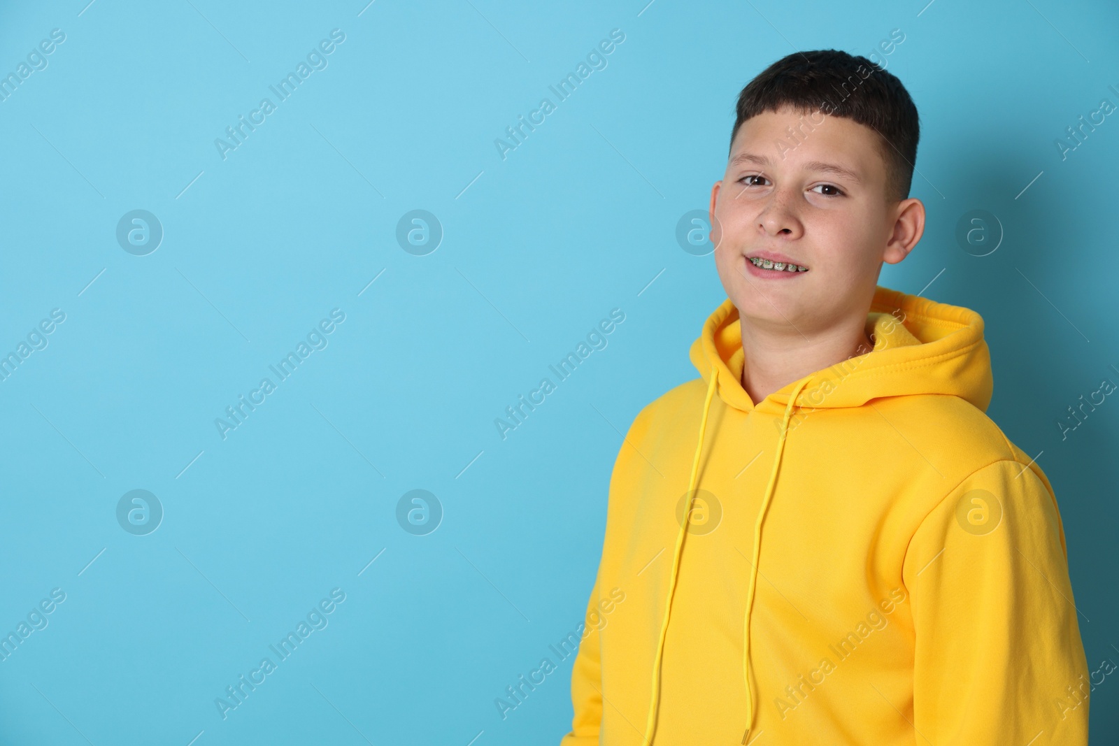 Portrait of teenage boy on light blue background, space for text Photo of Portrait of teenage boy on light blue background, space for text