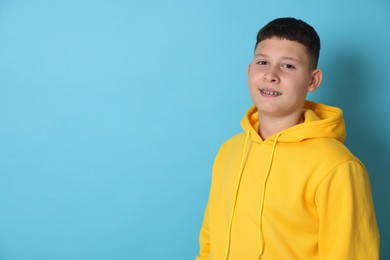 Photo of Portrait of teenage boy on light blue background, space for text