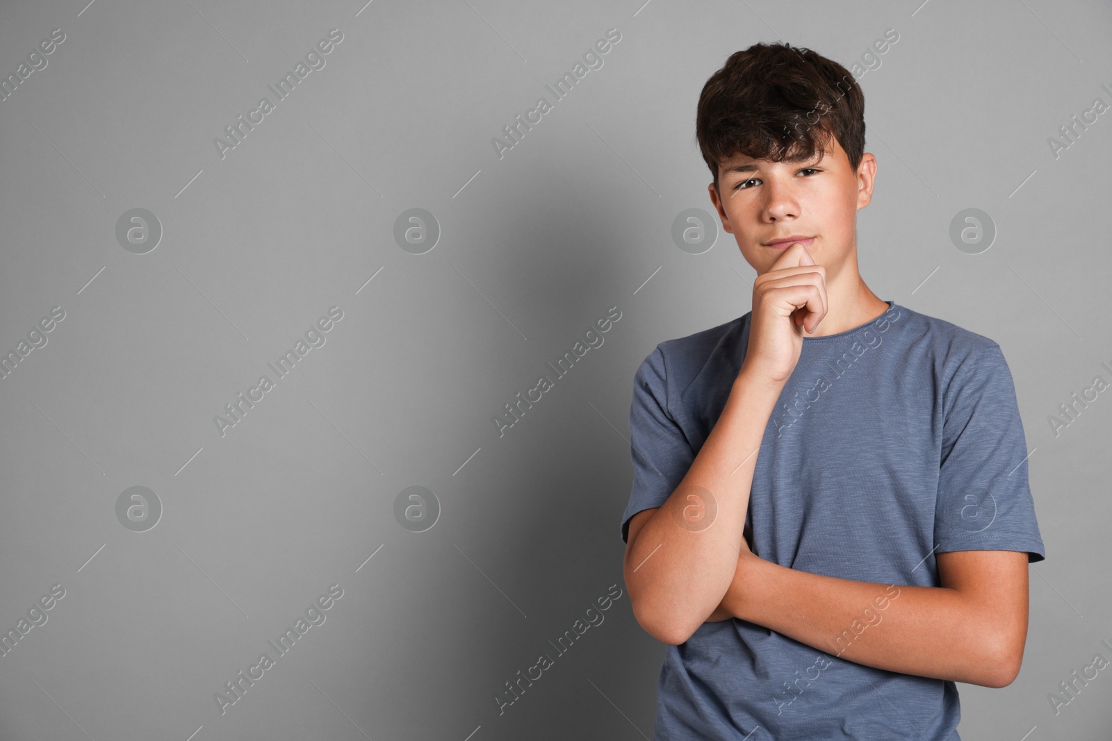 Portrait of teenage boy on grey background, space for text Photo of Portrait of teenage boy on grey background, space for text