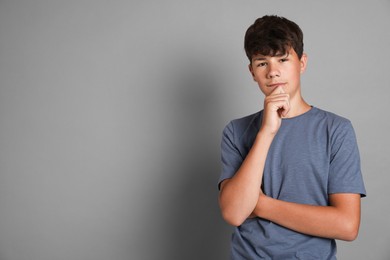 Photo of Portrait of teenage boy on grey background, space for text