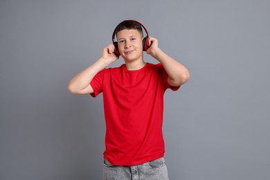 Photo of Teenage boy in headphones on grey background