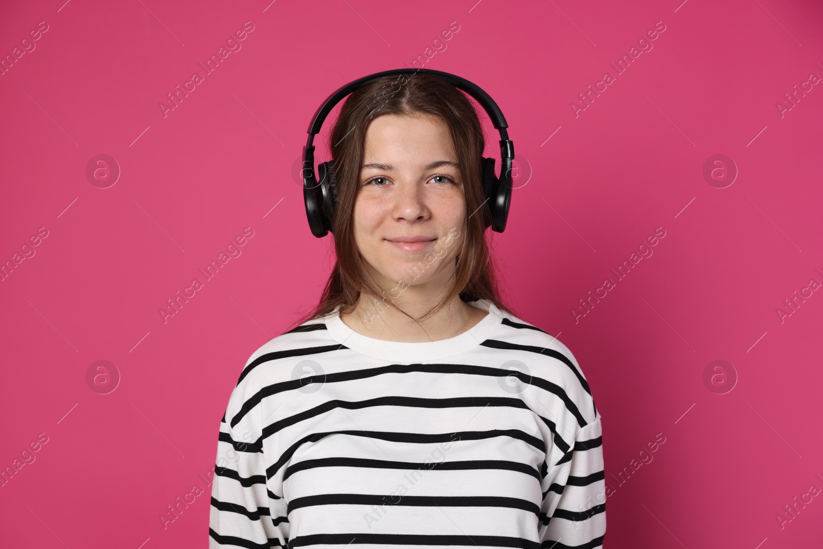 Photo of Teenage girl in headphones on crimson background