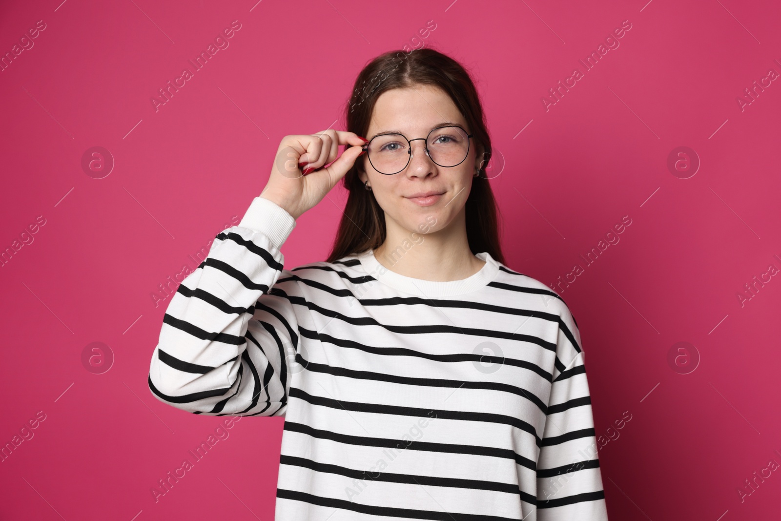 Teenage girl in glasses on crimson background Photo of Teenage girl in glasses on crimson background