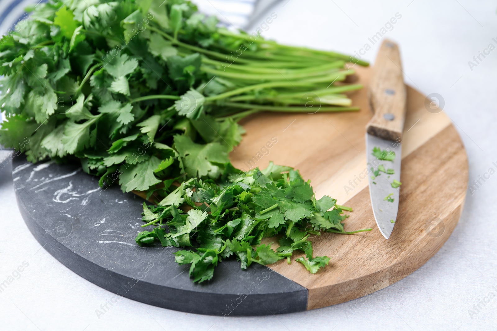 Fresh green cilantro and knife on light table, closeup Photo of Fresh green cilantro and knife on light table, closeup