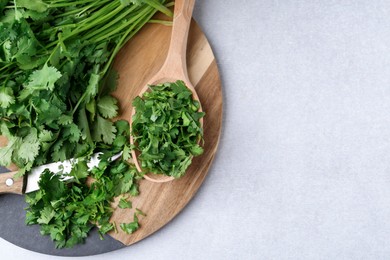 Photo of Fresh green cilantro and knife on light table, top view. Space for text
