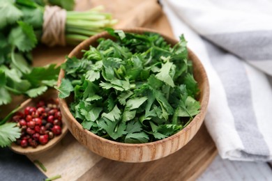 Photo of Fresh green cilantro and peppercorns on table, closeup