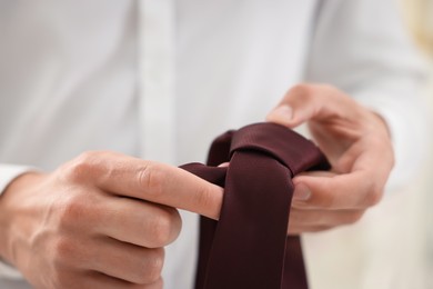 Photo of Man with stylish brown necktie at home, closeup