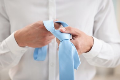 Photo of Man with stylish blue necktie at home, closeup
