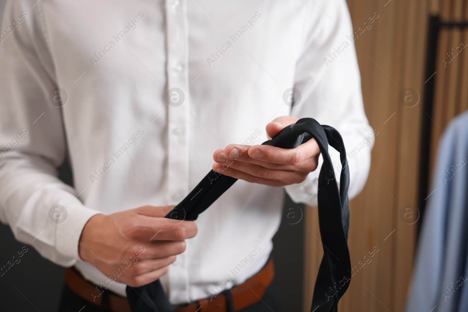Man with stylish black necktie at home, closeup Photo of Man with stylish black necktie at home, closeup