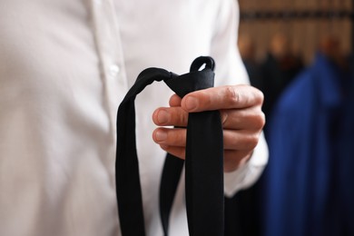 Photo of Man with stylish black necktie at home, closeup