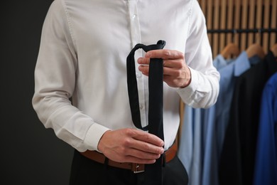 Photo of Man with stylish black necktie at home, closeup