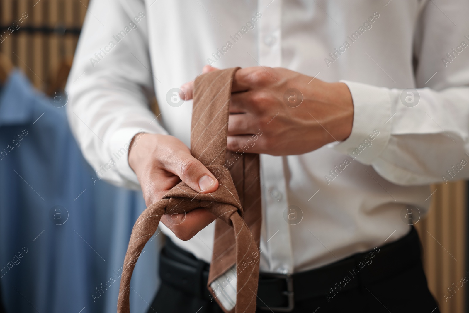Man with stylish brown necktie at home, closeup Photo of Man with stylish brown necktie at home, closeup