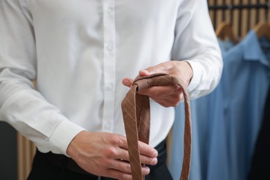 Photo of Man with stylish brown necktie at home, closeup
