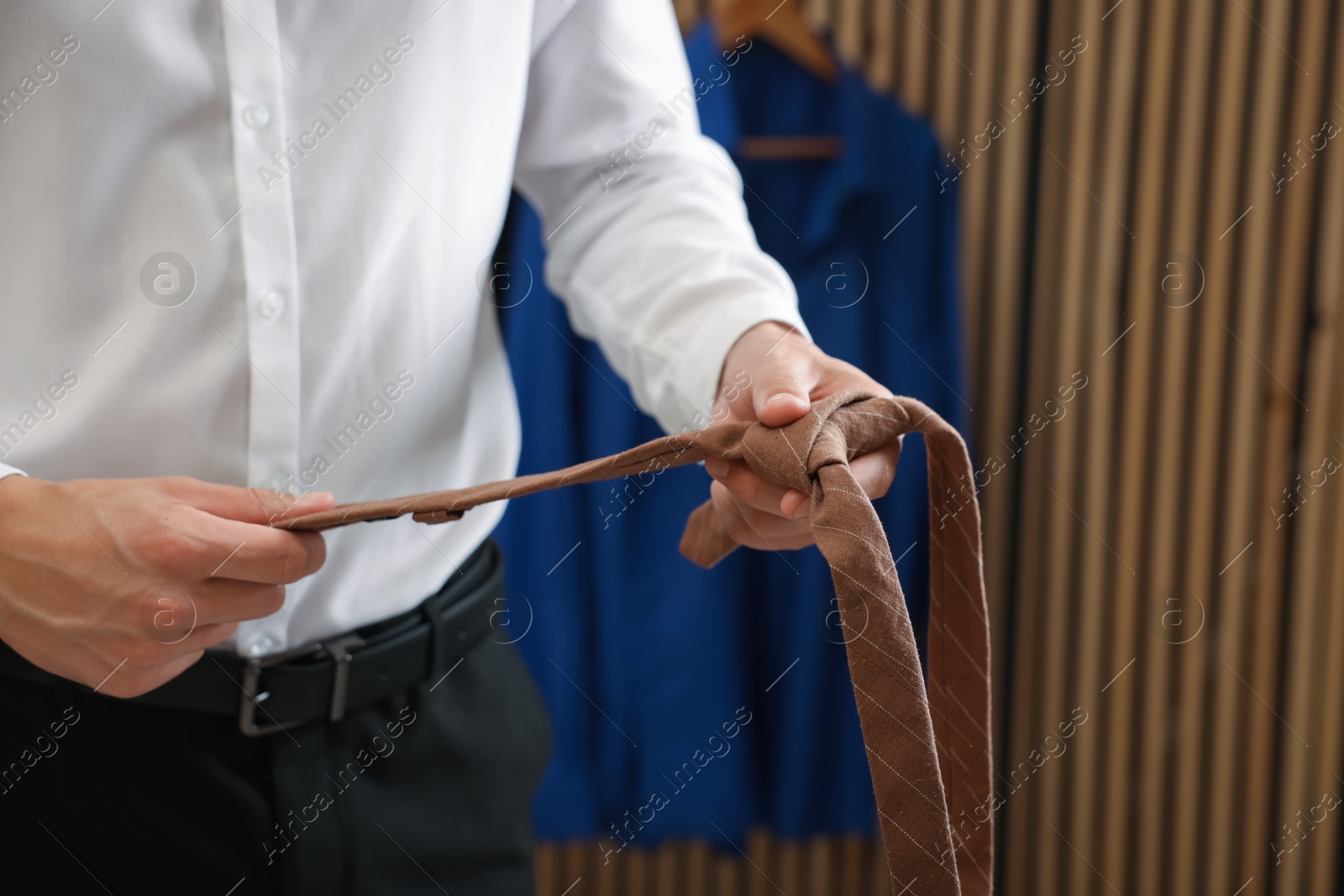 Man with stylish brown necktie at home, closeup Photo of Man with stylish brown necktie at home, closeup
