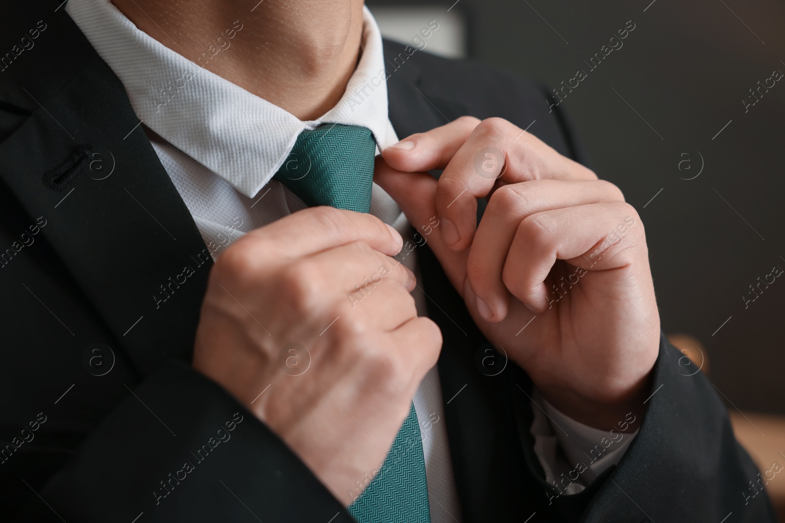 Man tying stylish necktie at home, closeup Photo of Man tying stylish necktie at home, closeup