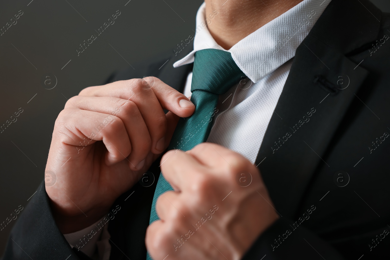 Man tying stylish necktie at home, closeup Photo of Man tying stylish necktie at home, closeup