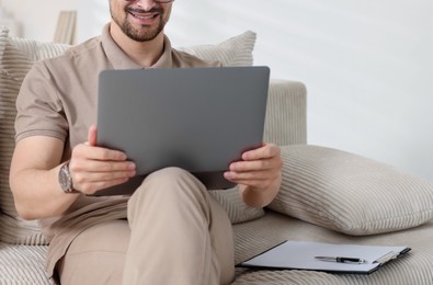 Photo of Professional psychologist having online consultation with his client via laptop on sofa indoors, closeup