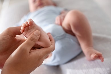 Photo of Pediatrician examining baby at table in clinic, closeup