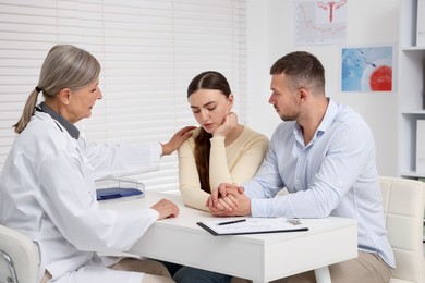 Photo of In vitro fertilization (IVF). Upset couple having consultation with doctor in reproductive clinic