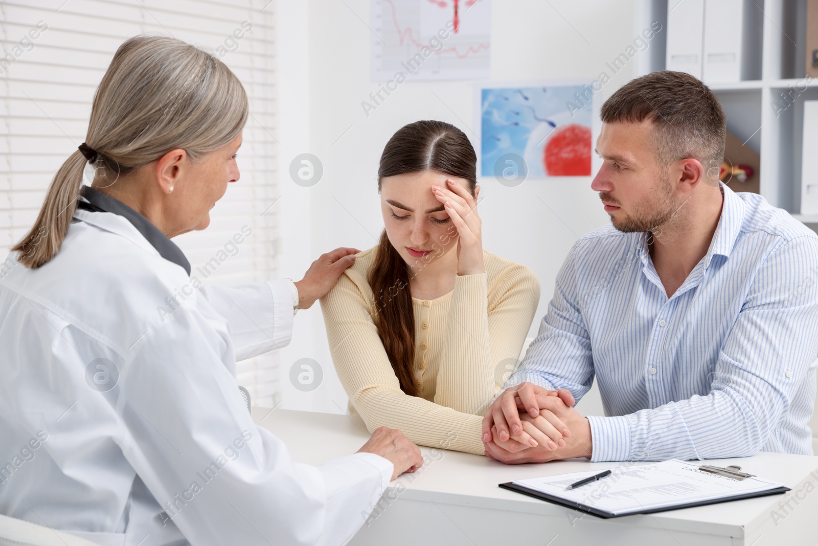 In vitro fertilization (IVF). Upset couple having consultation with doctor in reproductive clinic Photo of In vitro fertilization (IVF). Upset couple having consultation with doctor in reproductive clinic