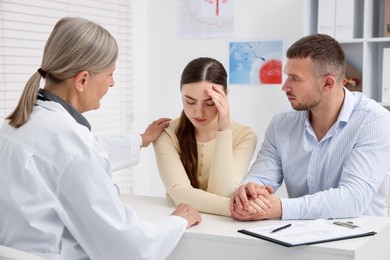 Photo of In vitro fertilization (IVF). Upset couple having consultation with doctor in reproductive clinic