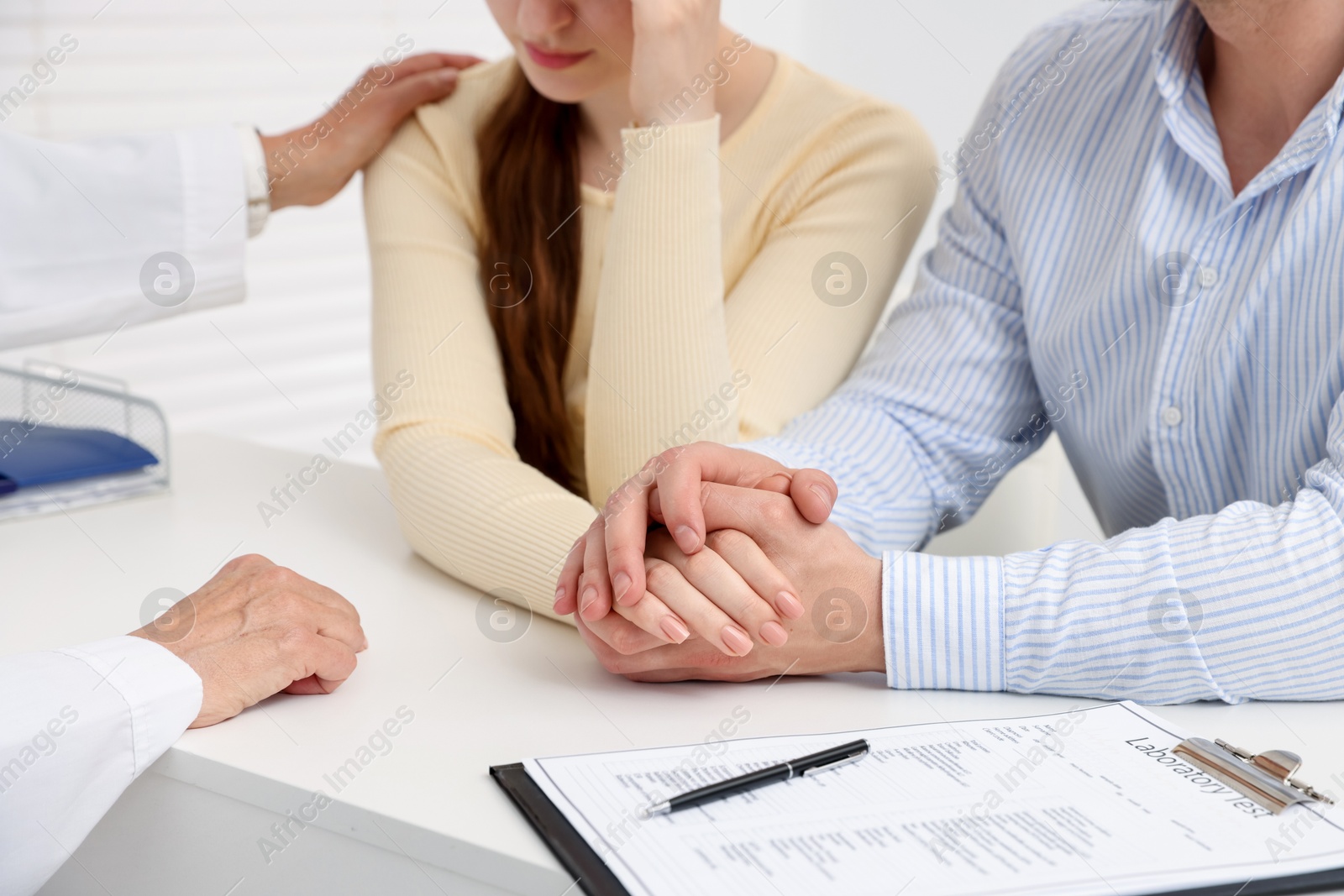 In vitro fertilization (IVF). Upset couple having consultation with doctor in reproductive clinic, closeup Photo of In vitro fertilization (IVF). Upset couple having consultation with doctor in reproductive clinic, closeup