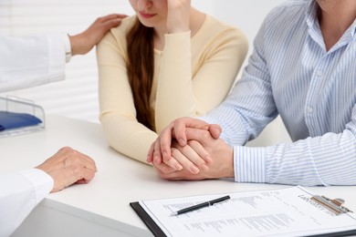 Photo of In vitro fertilization (IVF). Upset couple having consultation with doctor in reproductive clinic, closeup
