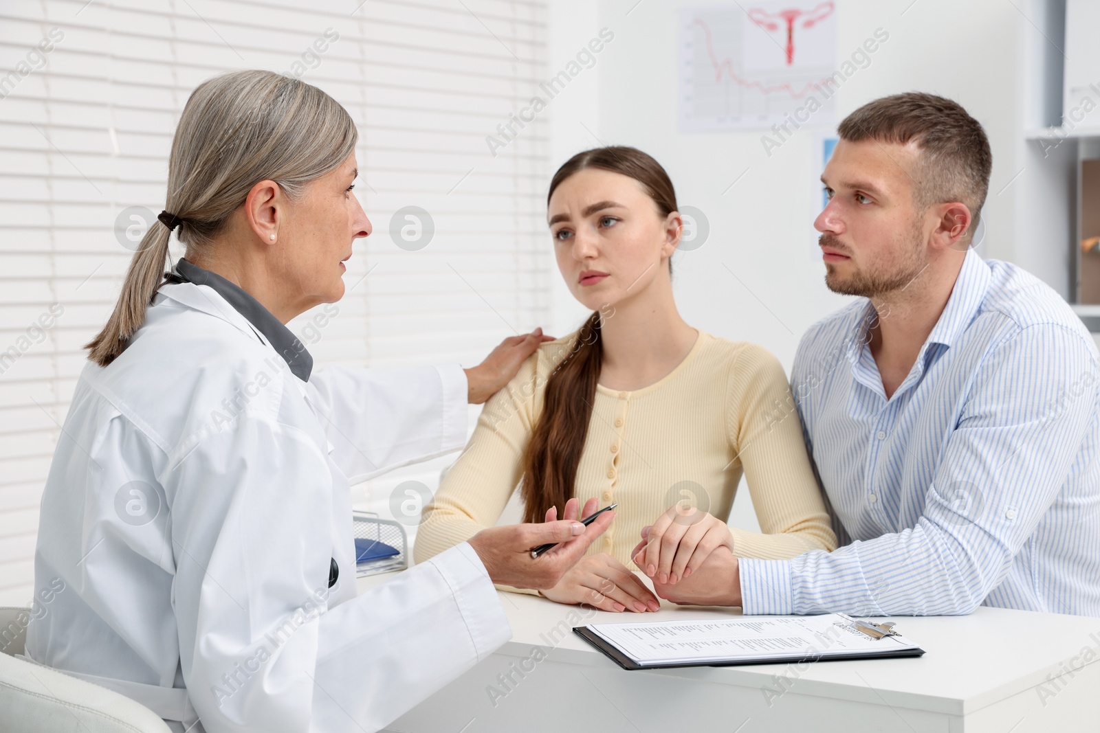 In vitro fertilization (IVF). Upset couple having consultation with doctor in reproductive clinic Photo of In vitro fertilization (IVF). Upset couple having consultation with doctor in reproductive clinic