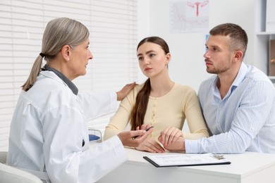 Photo of In vitro fertilization (IVF). Upset couple having consultation with doctor in reproductive clinic