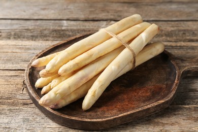 Photo of Raw white asparagus spears on wooden table, closeup