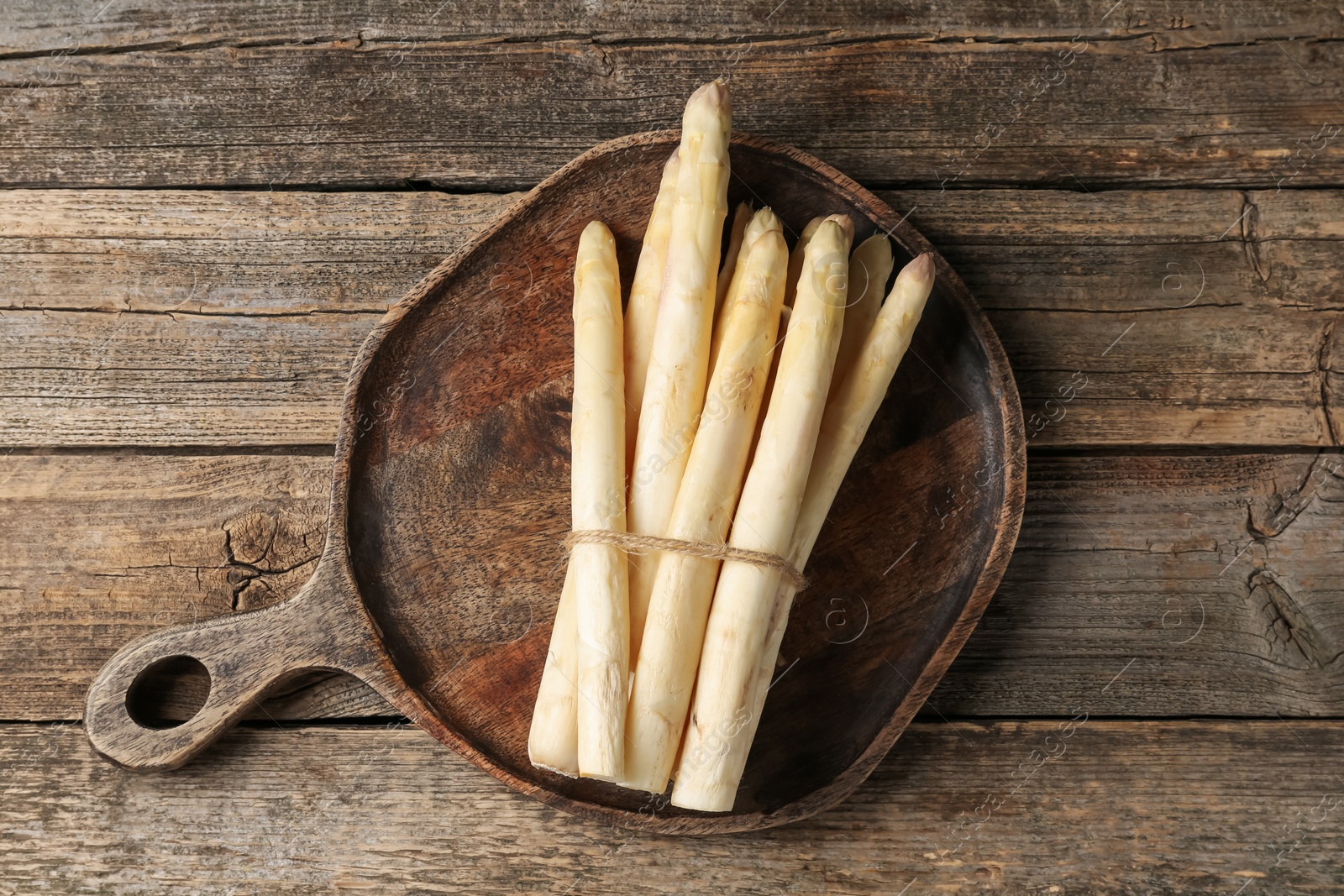 Bunch of raw white asparagus spears on wooden table, top view Photo of Bunch of raw white asparagus spears on wooden table, top view