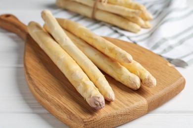 Photo of Raw asparagus spears on white wooden table, closeup