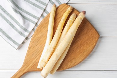 Photo of Raw asparagus spears on white wooden table, top view