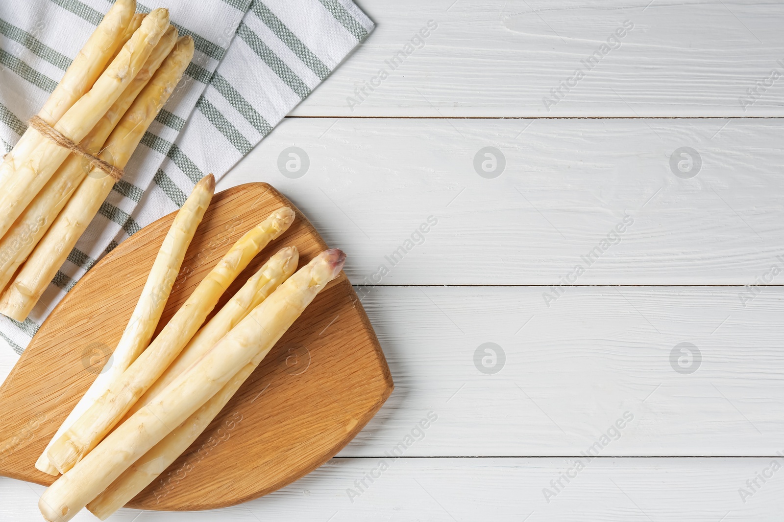Raw asparagus spears on white wooden table, flat lay. Space for text Photo of Raw asparagus spears on white wooden table, flat lay. Space for text