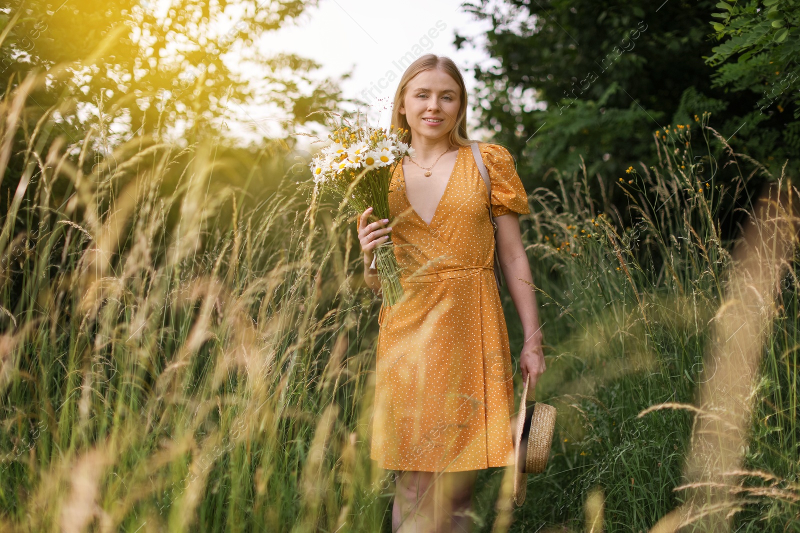 Beautiful woman with bouquet of wildflowers in meadow Photo of Beautiful woman with bouquet of wildflowers in meadow