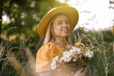 Photo of Beautiful woman with bouquet of wildflowers in meadow