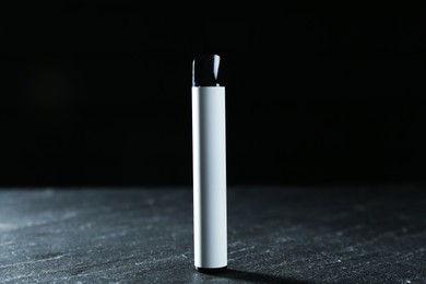 Photo of Modern electronic smoking device on black table