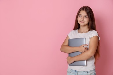Photo of Teenage girl with laptop on pink background, space for text
