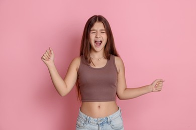 Photo of Portrait of teenage girl on pink background
