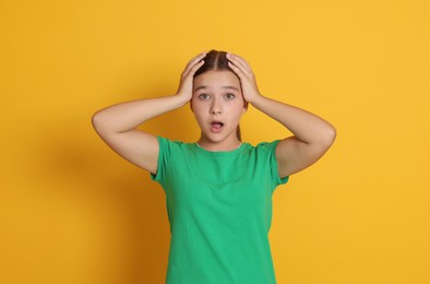 Photo of Portrait of shocked teenage girl on orange background