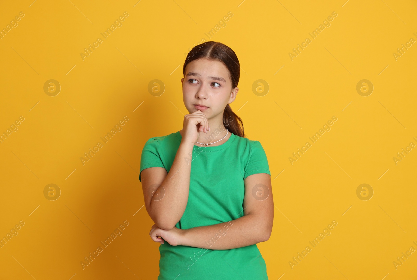 Portrait of teenage girl on orange background Photo of Portrait of teenage girl on orange background